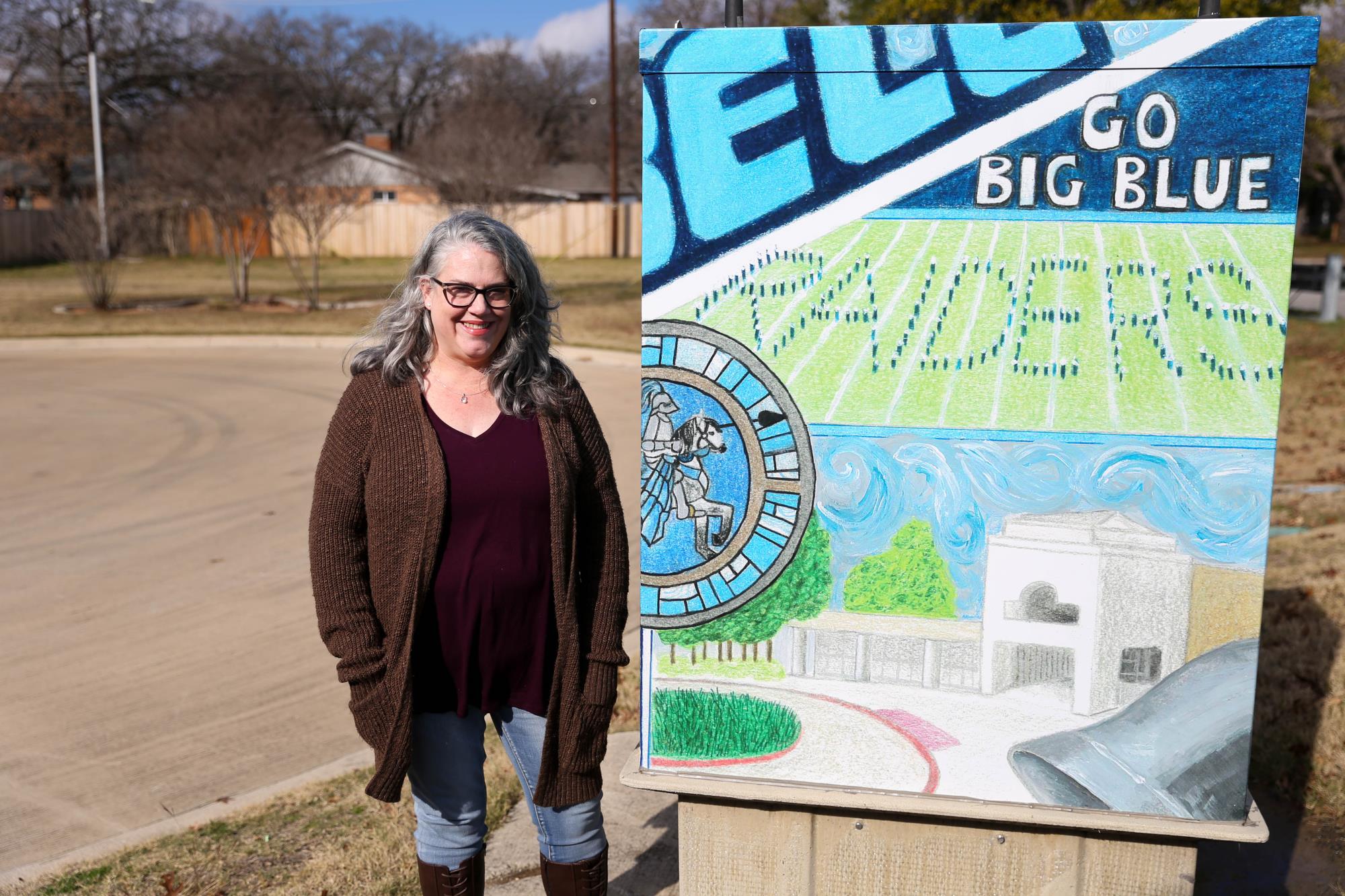 Artist Amanda Starnes posing with her utility box artwork of LD Bell imagery