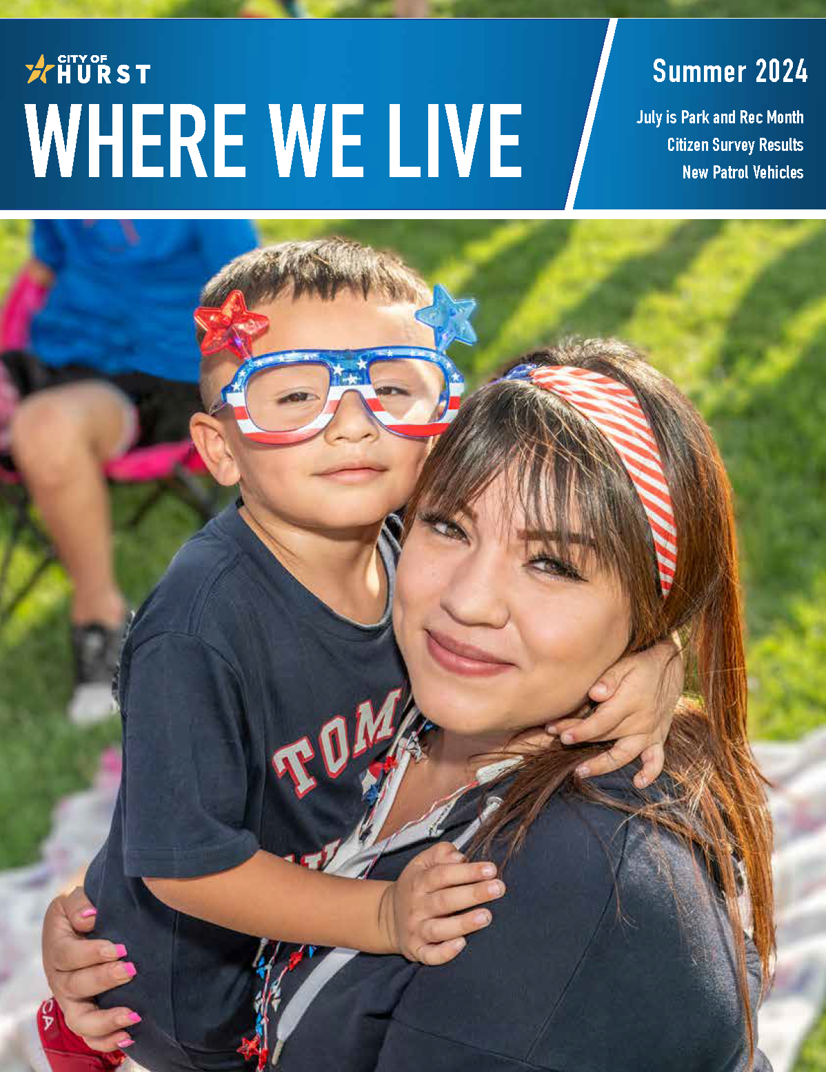 cover image of the Summer 2024 Where We Live Magazine Mother holding son with fourth of july glasses on